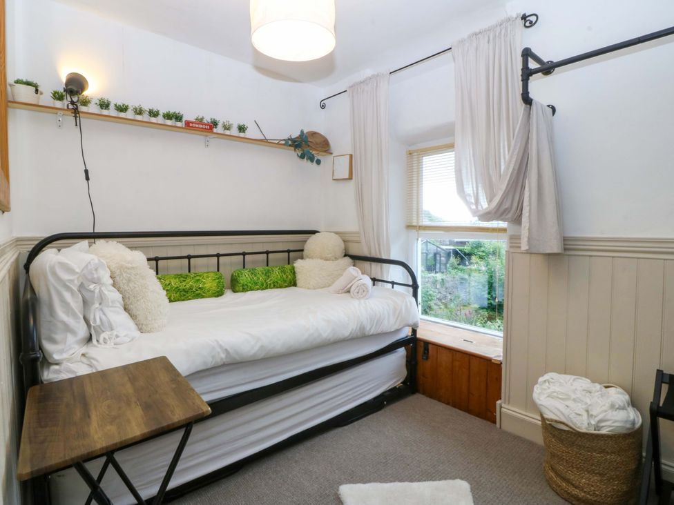 A bedroom with a bed and shelf at Waterfall Retreat in Blaenau Ffestiniog