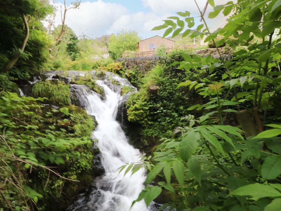 A waterfall surrounded by greenery at Waterfall Retreat in Blaenau Ffestiniog