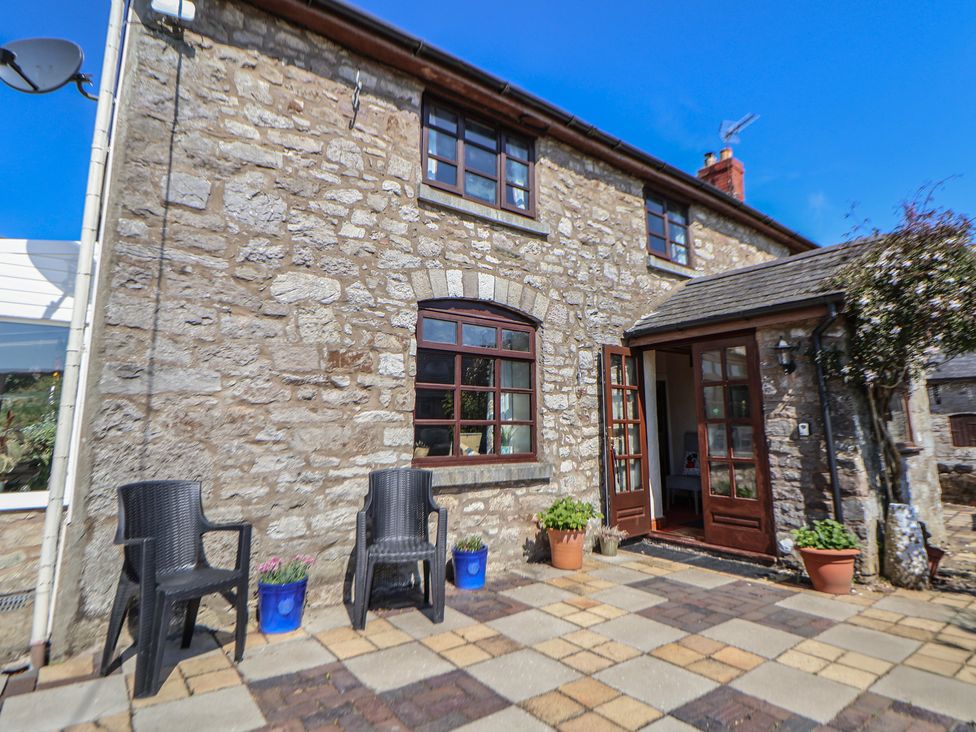 An outdoor area with chairs and flower pots at Cynynion Uchaf Rhydycroesau near Trefonen