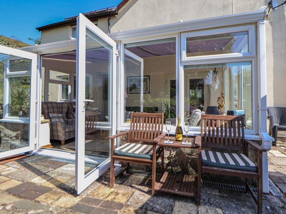 A conservatory with seating and a table at Cynynion Uchaf in Rhydycroesau near Trefonen