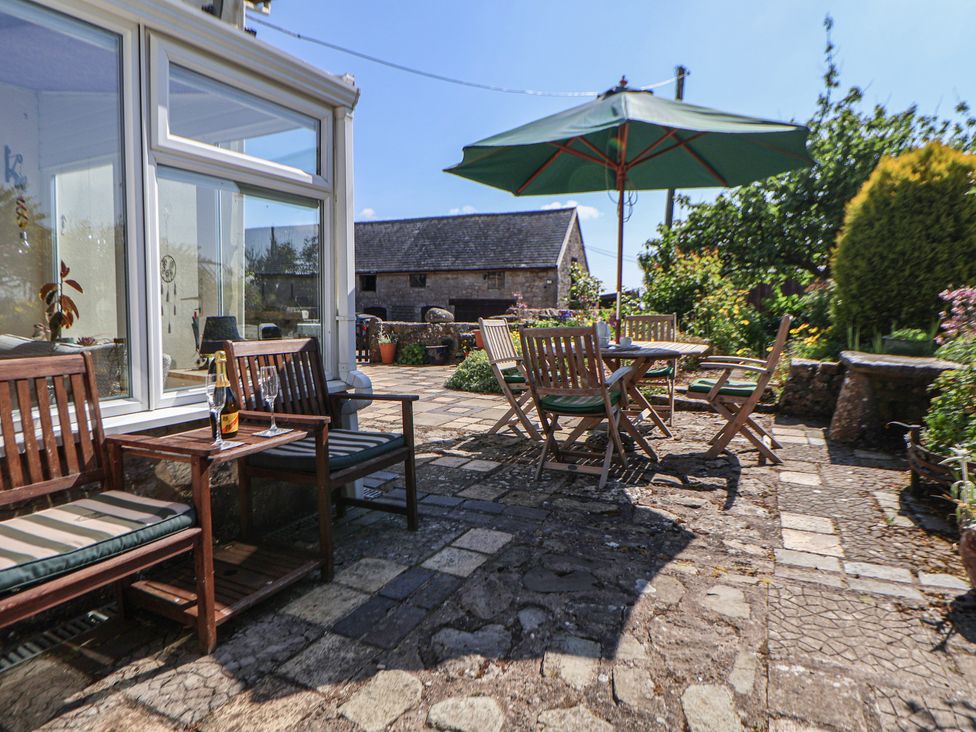 A garden with wooden furniture and plants at Cynynion Uchaf Rhydycroesau near Trefonen