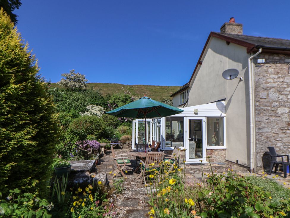 A garden with a patio and seating arrangement at Cynynion Uchaf, Rhydycroesau near Trefonen