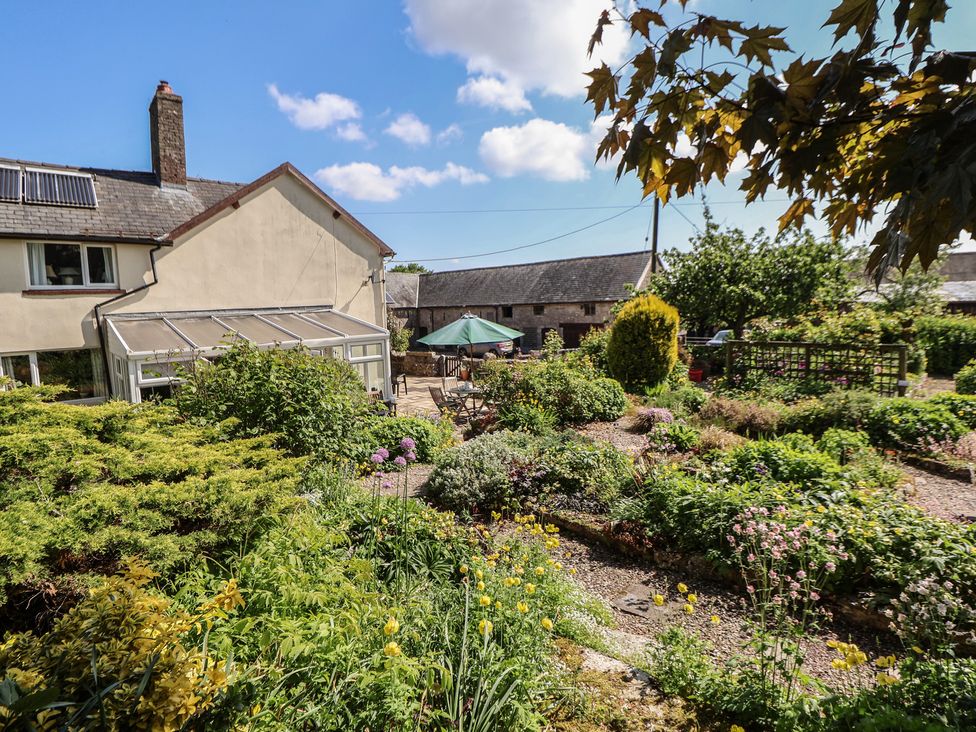 A garden with flowers and a patio area at Cynynion Uchaf in Rhydycroesau near Trefonen