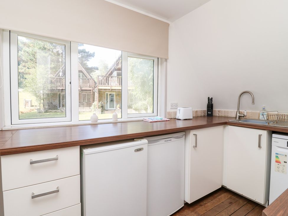 A kitchen with a sink and fridge at Valley Lodge 37 St Ann's Chapel, Cornwall