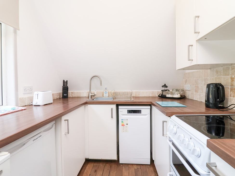A kitchen featuring a sink, stove and dishwasher at Valley Lodge 37, St Ann's Chapel, Cornwall