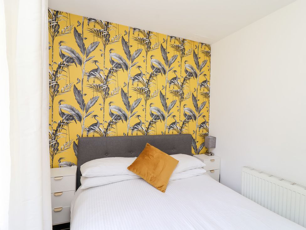 A bedroom with a bed and floral wallpaper at Valley Lodge 37 St Ann's Chapel, Cornwall
