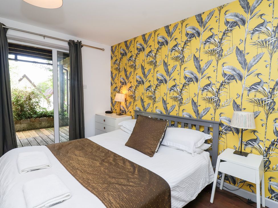 A bedroom with a bed and sliding doors at Valley Lodge 37, St Ann's Chapel, Cornwall