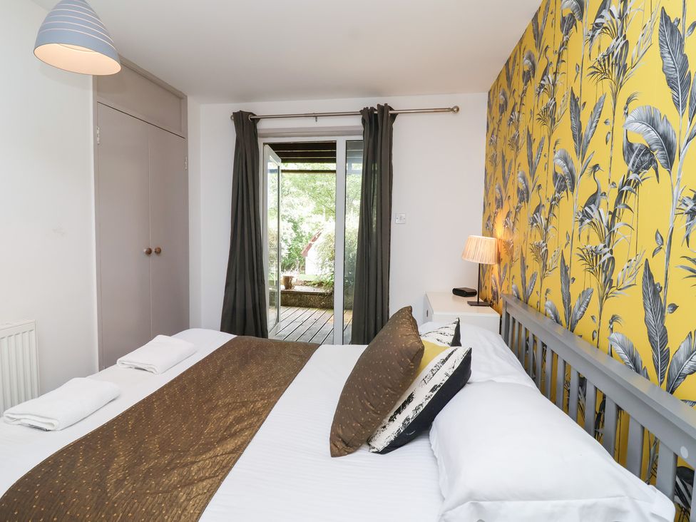 A bedroom with a double bed and patio door at Valley Lodge 37 St Ann's Chapel, Cornwall
