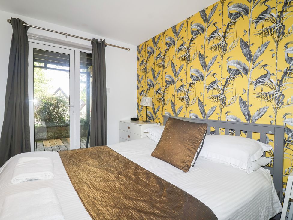 A bedroom with a bed and sliding door at Valley Lodge 37 St Ann's Chapel, Cornwall