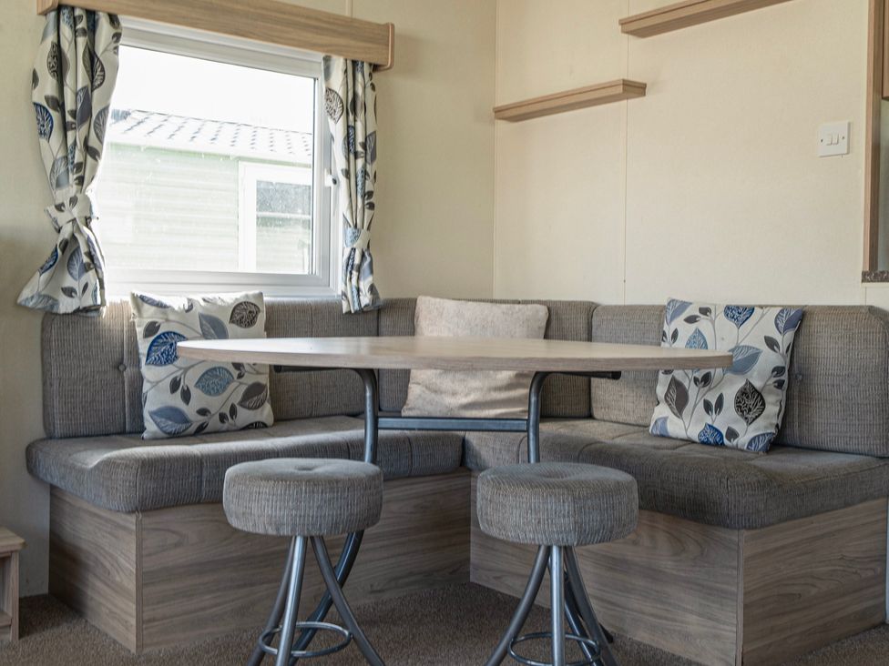 A dining area with a table and seating at Duckling Den - Billing Aquadrome