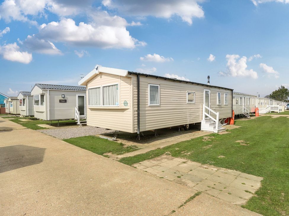 A static caravan outside with grass and a pathway at Duckling Den - Billing Aquadrome