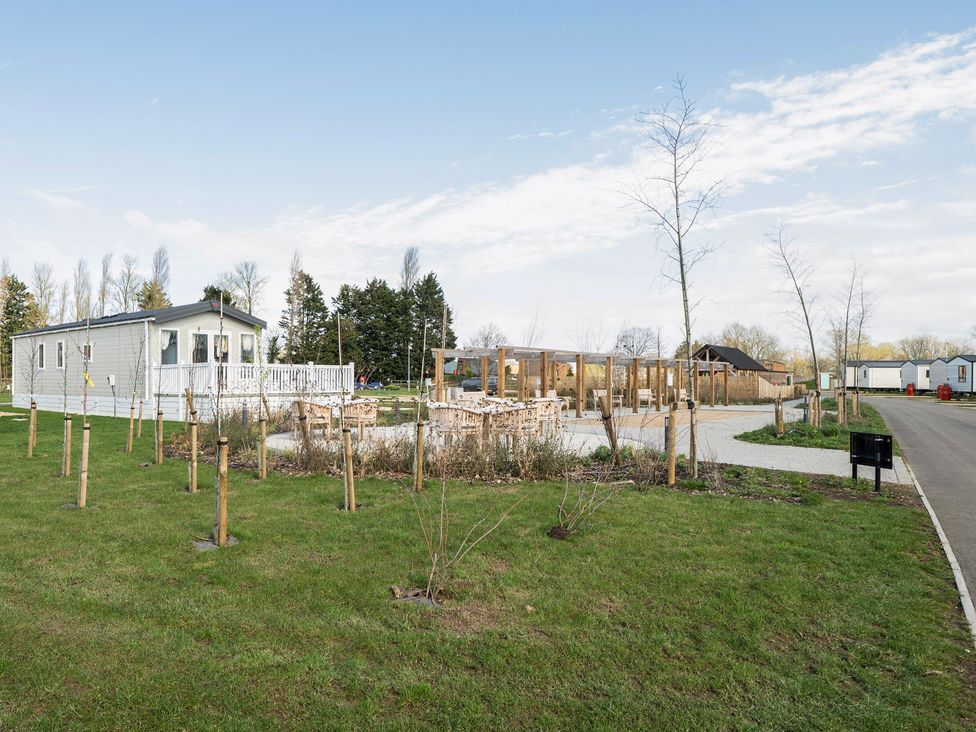 An outdoor area with a mobile home and seating near Duckling Den - Billing Aquadrome