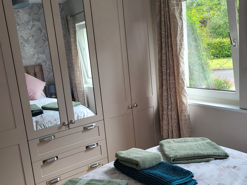 A bedroom with a bed and towels on the bedside at Beech Lodge in Foulksmills, County Wexford