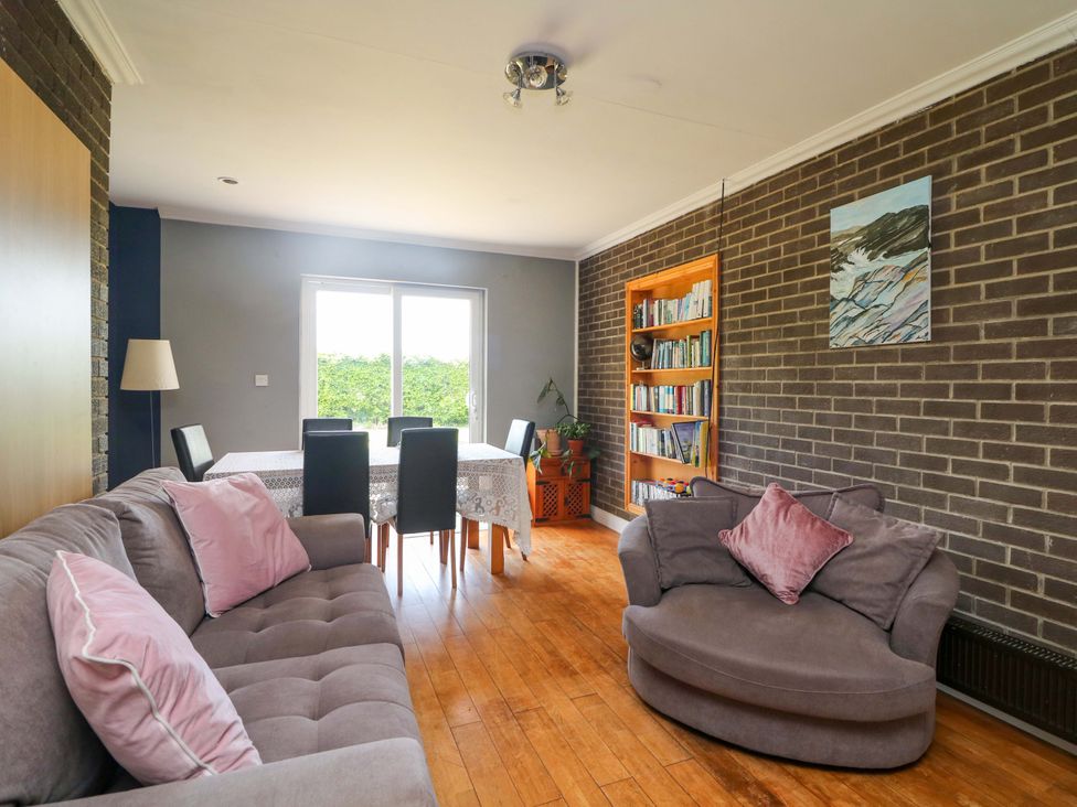 A living room with a sofa and dining table at Beech Lodge, Foulksmills, County Wexford