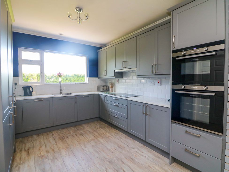 A kitchen with cabinets, ovens, kettle and sink at Beech Lodge, Foulksmills, County Wexford