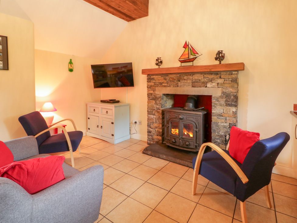 A living room with a fireplace and television at Shane's Cottage in Falcarragh, County Donegal