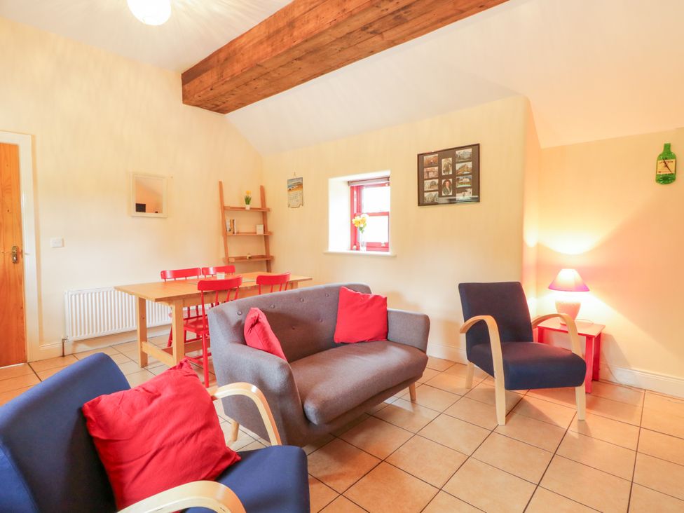 A living room with a sofa and dining table at Shane's Cottage, Falcarragh, County Donegal