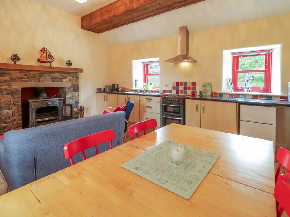 A kitchen with dining table and stove at Shane's Cottage in Falcarragh, County Donegal
