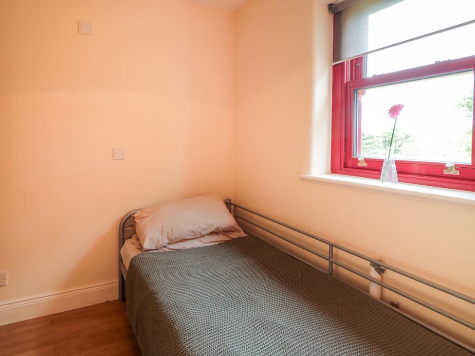 A bedroom with a bed and window at Shane's Cottage in Falcarragh, County Donegal