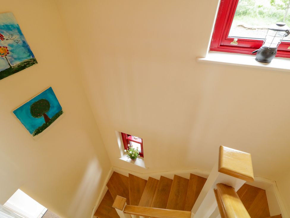A staircase with paintings on the wall at Shane's Cottage, Falcarragh, County Donegal