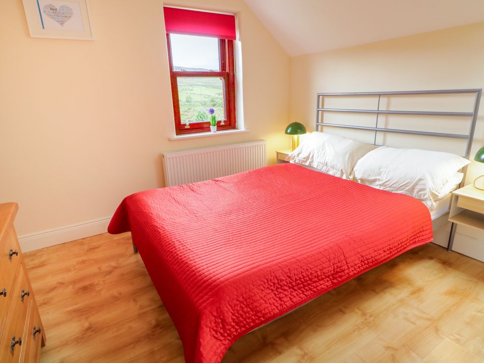 A bedroom with a bed and a bedside lamp at Shane's Cottage, Falcarragh, County Donegal