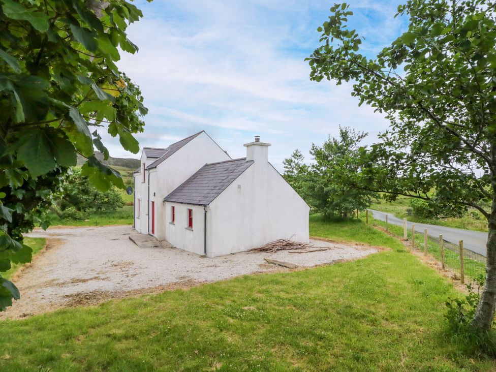 An exterior view of a house with gravel and grass at Shane's Cottage in Falcarragh, County Donegal