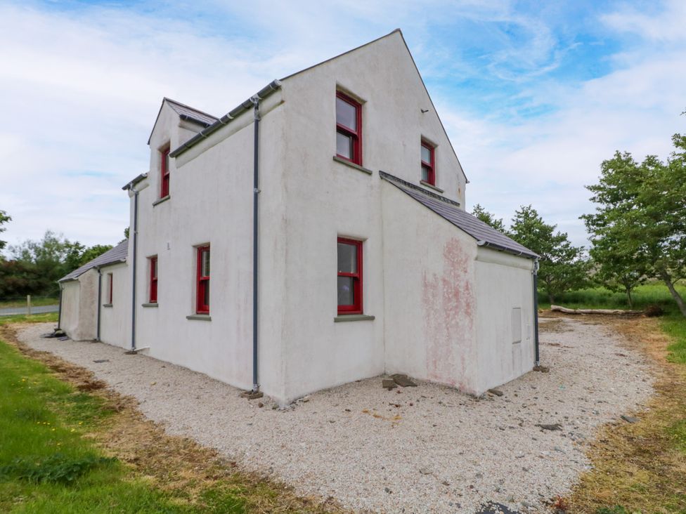 A house with red windows and a gravel pathway at Shane's Cottage, Falcarragh, County Donegal