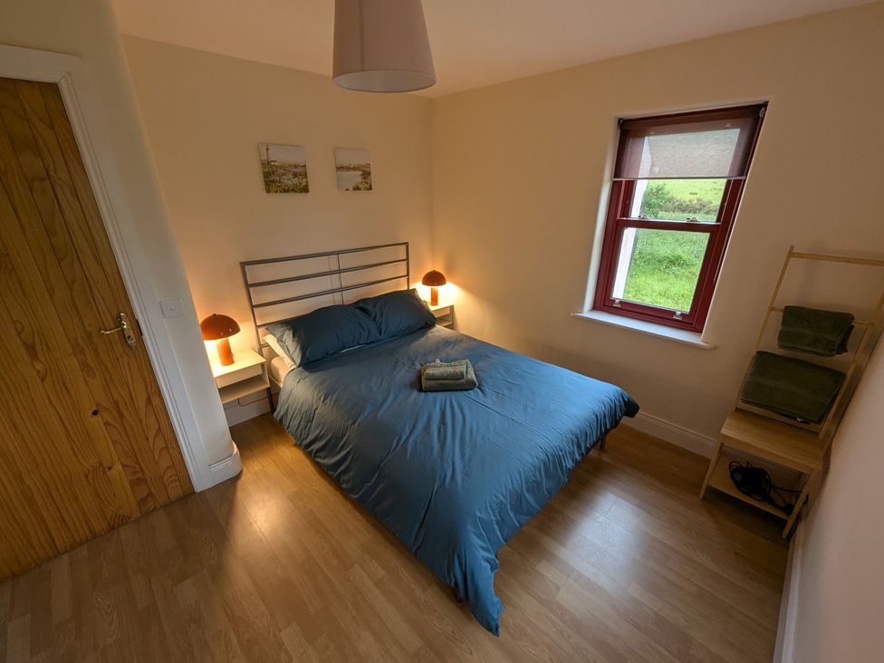 A bedroom with a bed and bedside tables at Shane's Cottage, Falcarragh, County Donegal