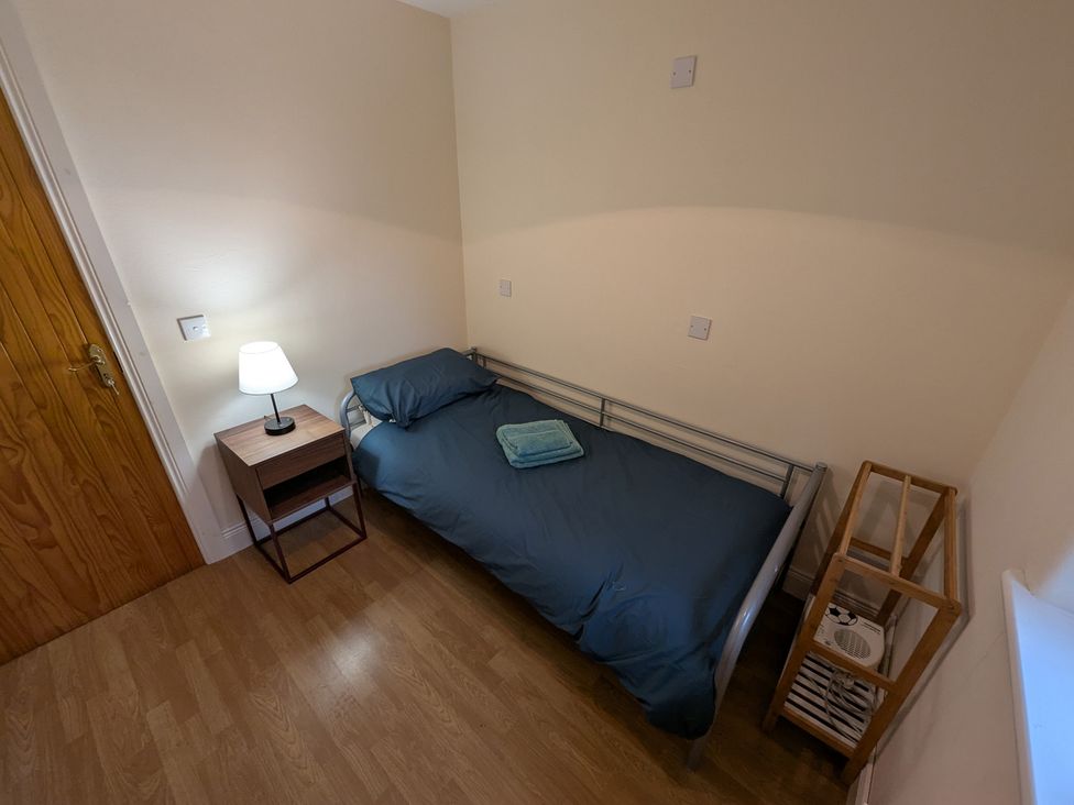 A bedroom with a bed and lamp at Shane's Cottage in Falcarragh, County Donegal
