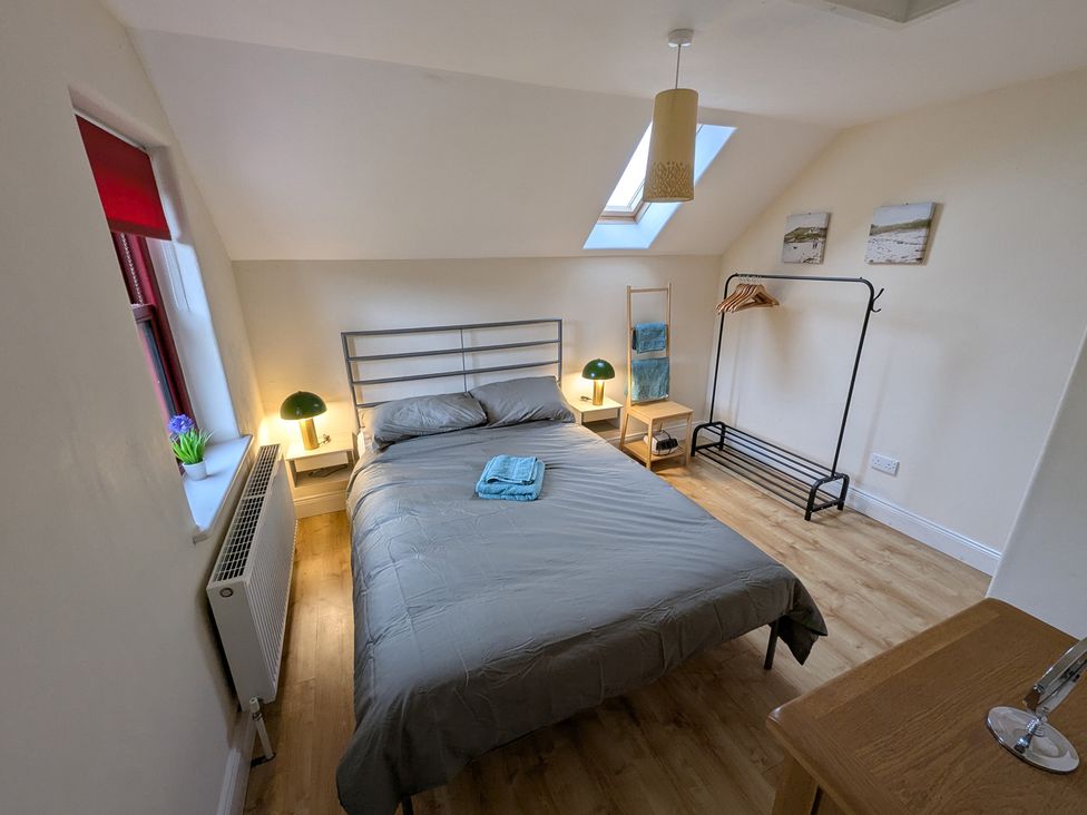 A bedroom with a bed and a bedside lamp at Shane's Cottage in Falcarragh, County Donegal