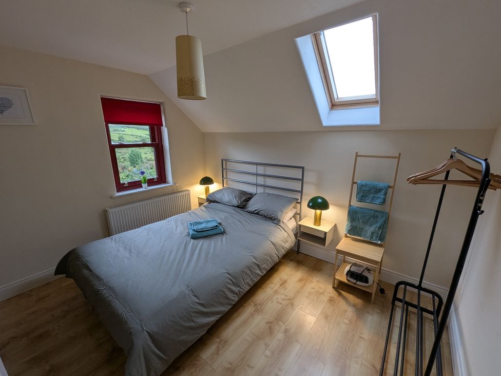 A bedroom with a bed and bedside table at Shane's Cottage in Falcarragh, County Donegal