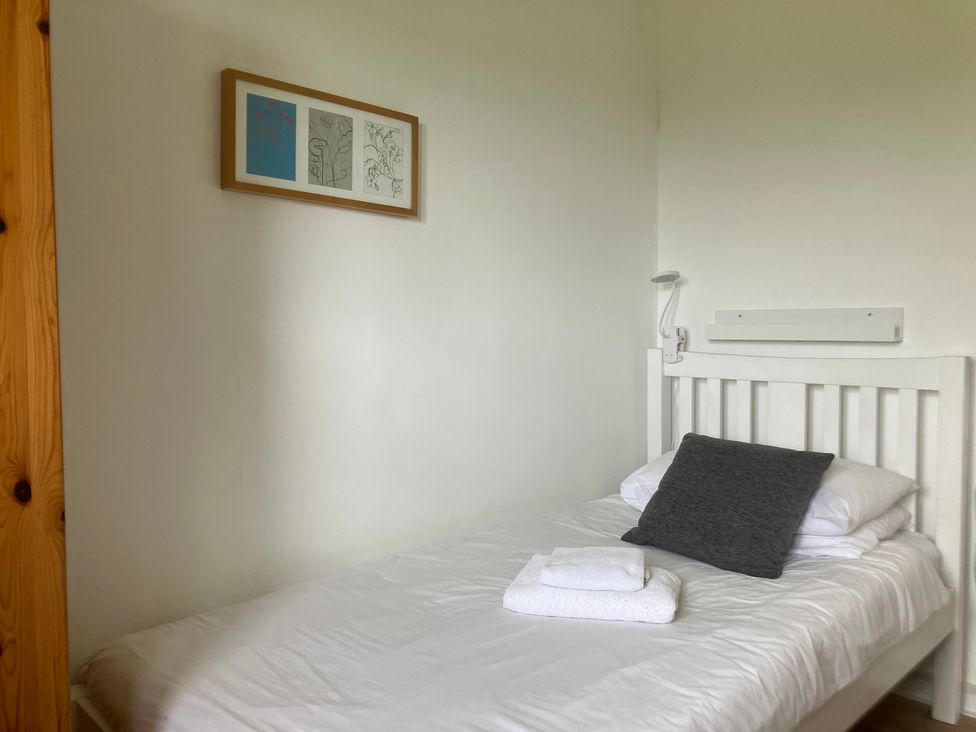 A bedroom with a bed and wall art at Island View Lodge, Back of Keppoch near Arisaig