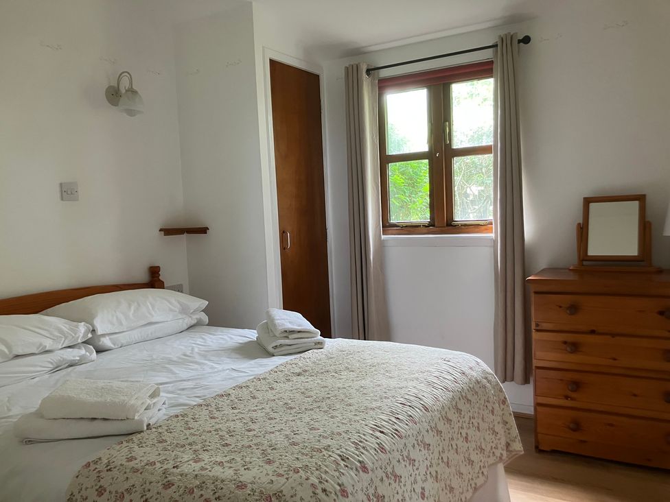 A bedroom with a bed and dresser at Island View Lodge Back of Keppoch near Arisaig