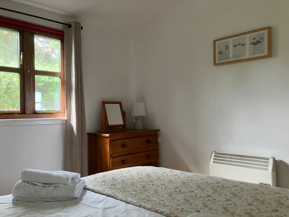 A bedroom with a bed and a chest of drawers at Island View Lodge in Back of Keppoch near Arisaig