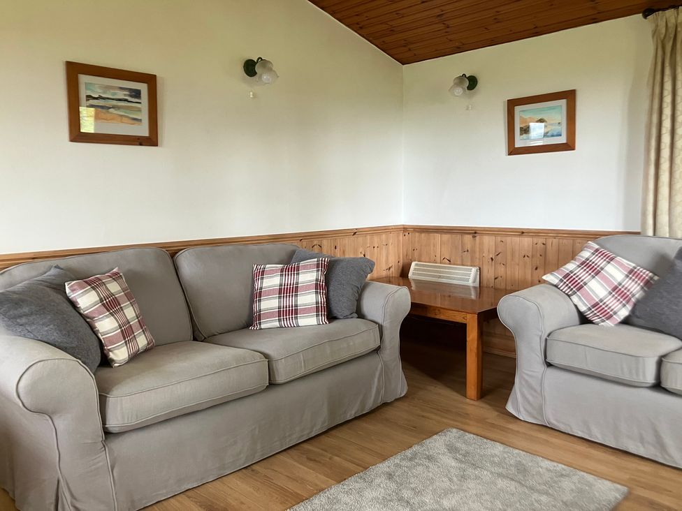 A living room with sofas and wooden table at Island View Lodge in Back of Keppoch near Arisaig