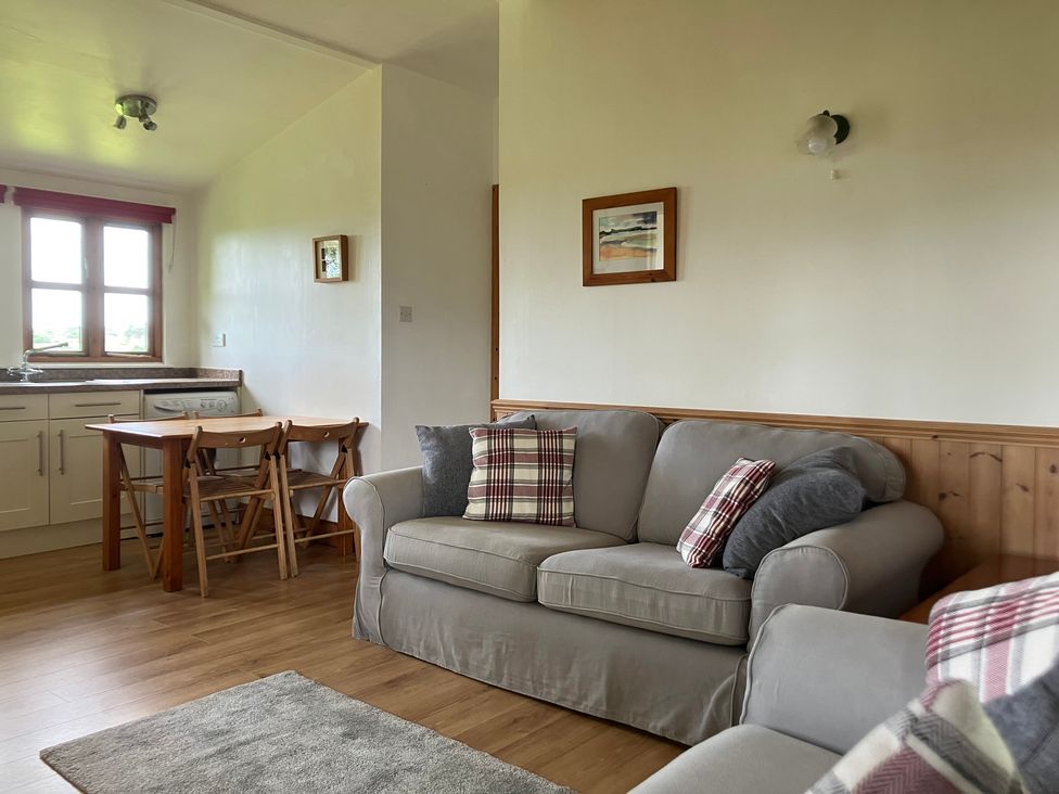 A living room with a sofa and dining table at Island View Lodge near Back of Keppoch Arisaig
