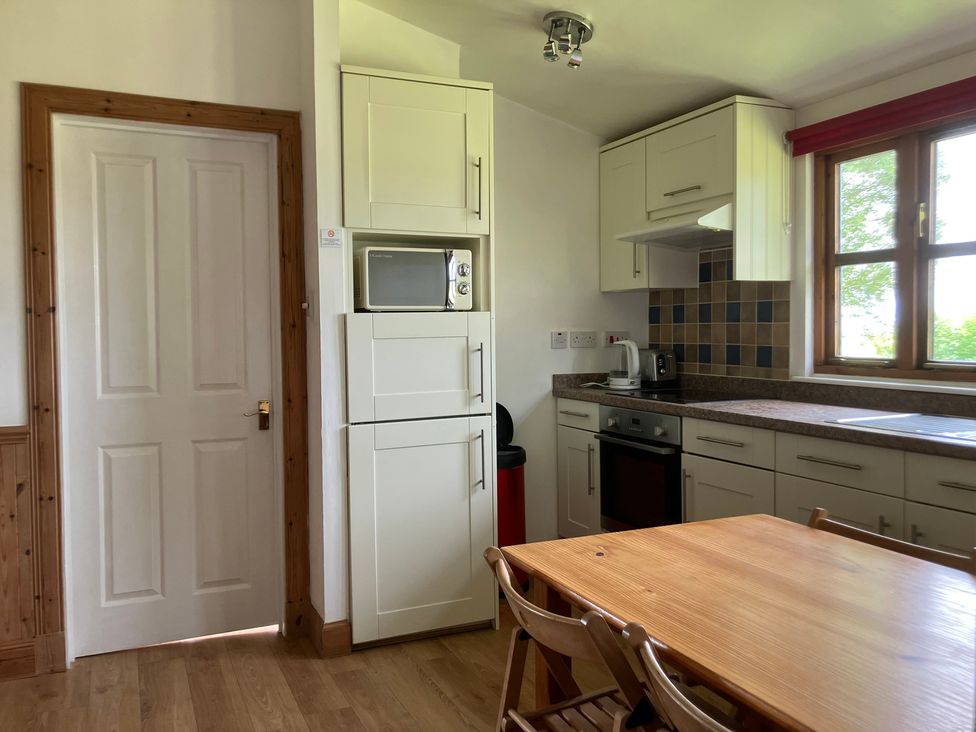 A kitchen with appliances and dining table at Island View Lodge Back of Keppoch near Arisaig