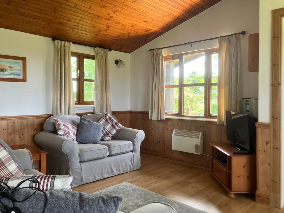 A living room with a sofa and television at Island View Lodge Back of Keppoch near Arisaig