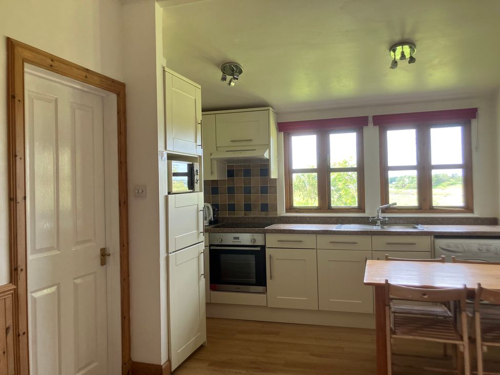 A kitchen with cabinets, a sink, and a stove at Island View Lodge near Back of Keppoch near Arisaig