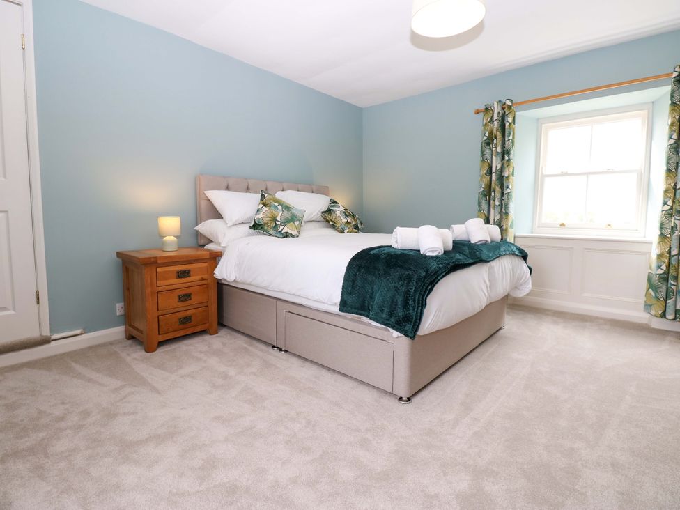 A bedroom with a bed and nightstand at Peace Cottage in Langton near Gainford