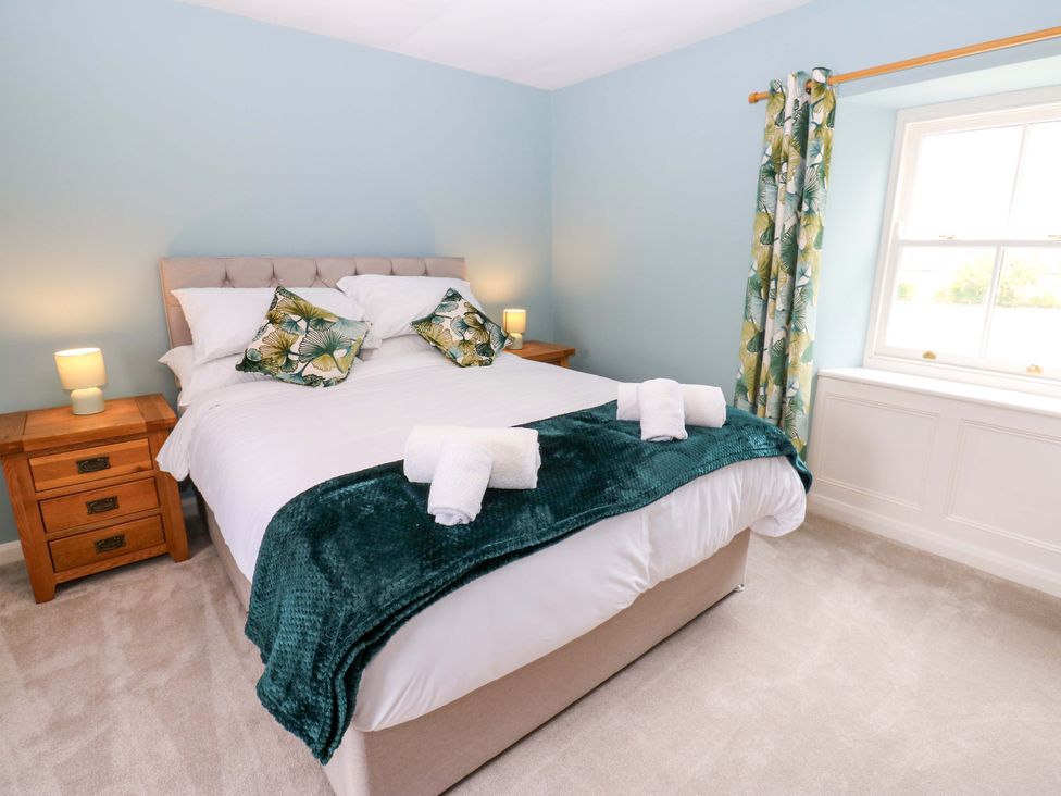 A bedroom with a bed and bedside tables at Peace Cottage in Langton near Gainford