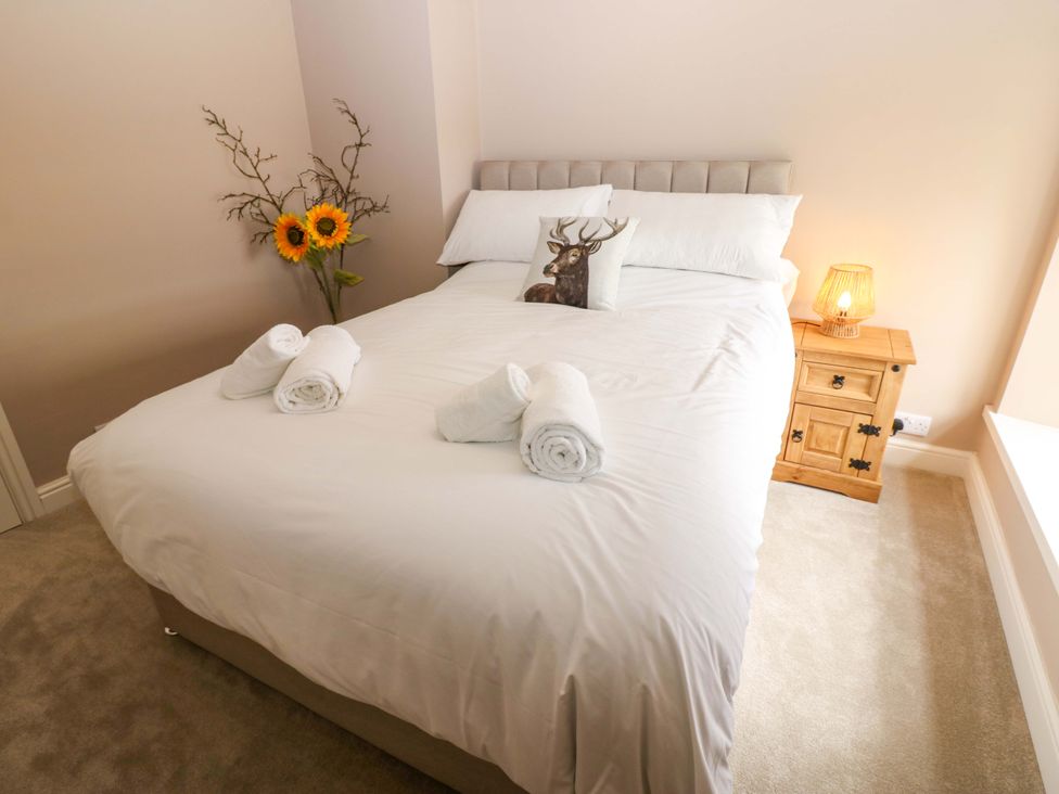 A bedroom with a bed and a nightstand at Peace Cottage in Langton near Gainford