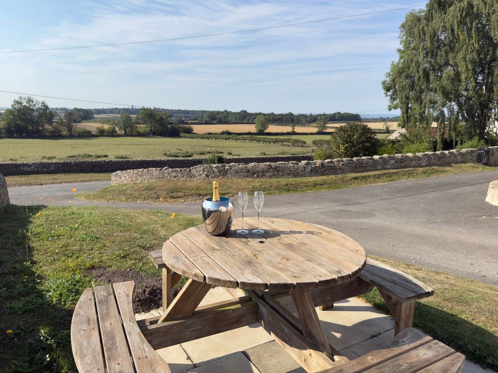 An outdoor seating area with a table and champagne at Peace Cottage in Langton near Gainford