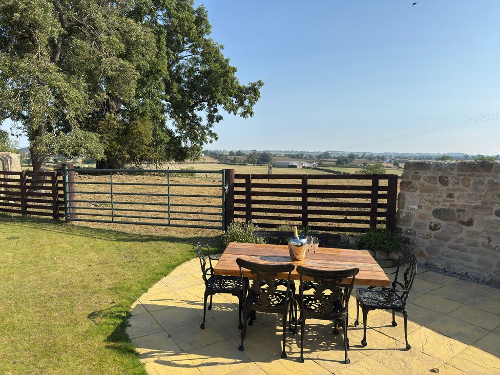 An outdoor seating area with a table and chairs at Peace Cottage in Langton near Gainford