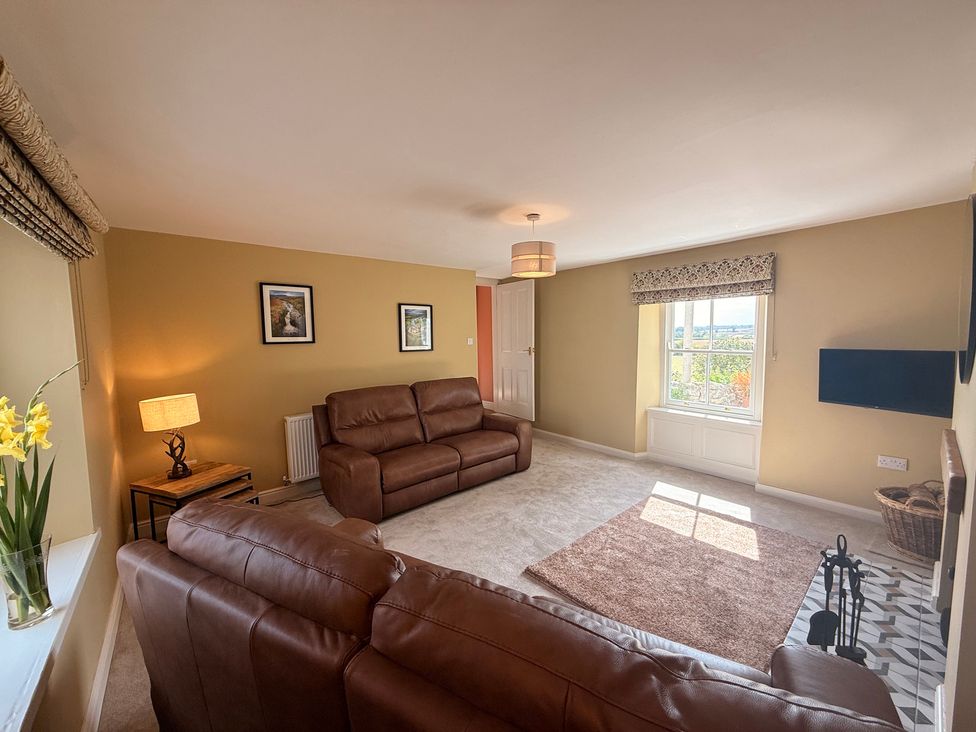A living room with a sofa and lamp at Peace Cottage in Langton near Gainford
