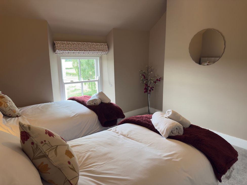 A bedroom with twin beds and a window at Peace Cottage Langton near Gainford
