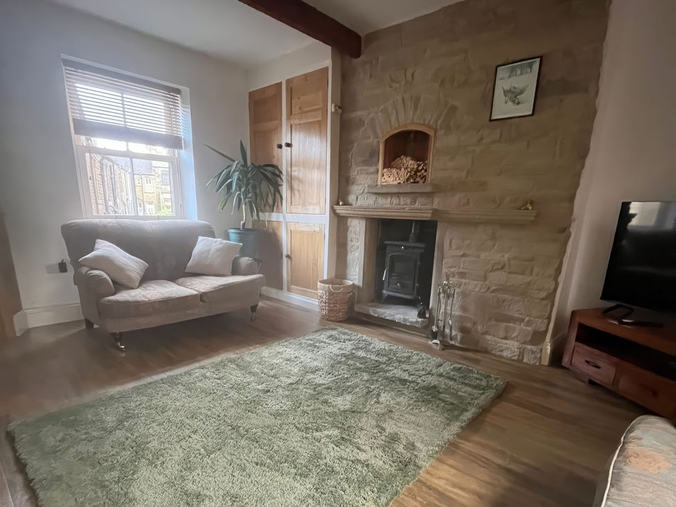 A living room with a sofa and fireplace at 12 Queen Street in Keighley