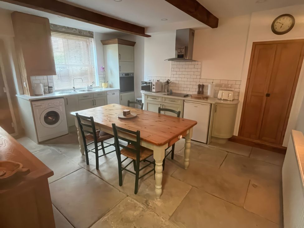 A kitchen with a table and chairs at 12 Queen Street Keighley