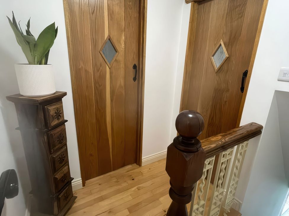 A hallway with wooden doors and a decorative cabinet at 12 Queen Street in Keighley