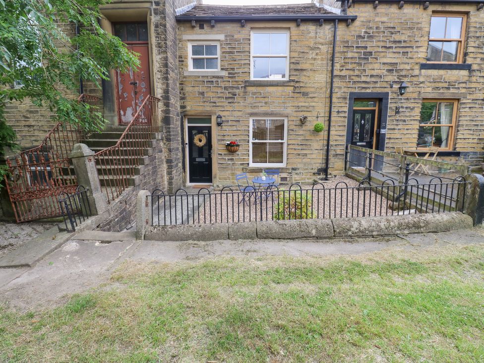 An outdoor area with a table and chairs at Hivewood Cottage in Haworth